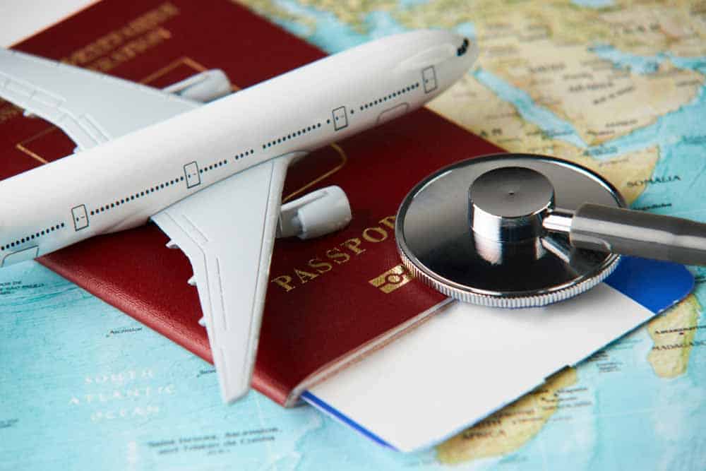 Medical travel image of map, passport and plane model.